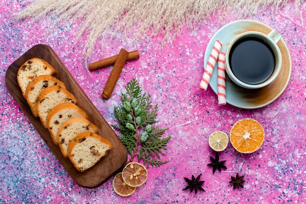 Vista de cima Bolo de passas delicioso em fatias de torta com uma xícara de café na superfície rosa assar torta de biscoito doce de açúcar