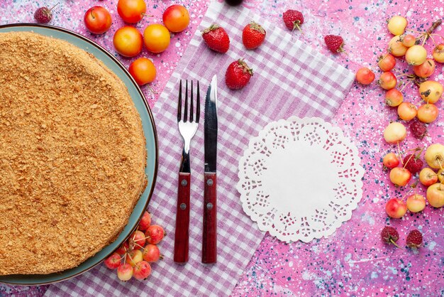 Vista de cima bolo redondo delicioso dentro do prato com frutas frescas na mesa rosa brilhante torta bolo biscoito doce assar açúcar