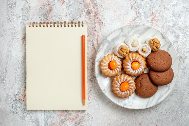 Foto grátis vista de cima bolos diferentes docinhos em fundo branco claro biscoito biscoito açúcar chá doce bolo