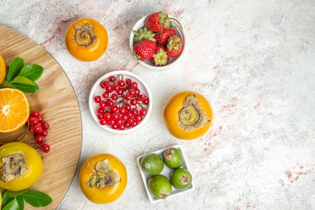 Vista de cima composição de frutas diferentes frutas na mesa branca cor de frutas vermelhas frescas maduras