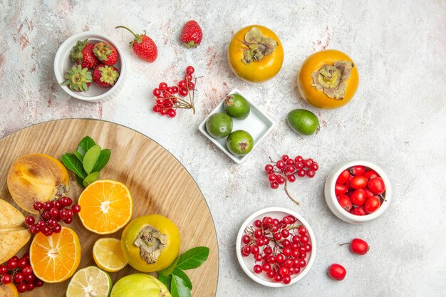 Vista de cima composição de frutas diferentes frutas na mesa branca cor de frutas vermelhas frescas maduras