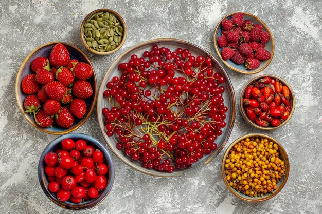 Vista de cima cranberries vermelhas frescas com outras frutas no fundo branco