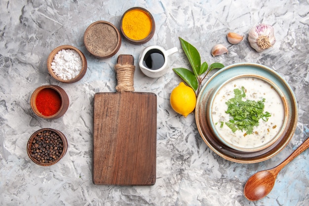 Vista de cima da deliciosa sopa de iogurte dovga com temperos no prato de sopa de leite branco