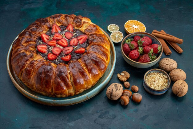 Vista de cima da torta de morango com nozes na mesa azul