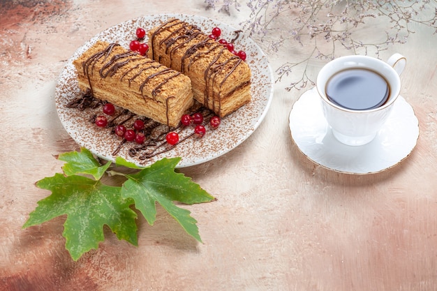 Vista de cima das fatias de bolo com cobertura de chocolate e frutas vermelhas em uma luz