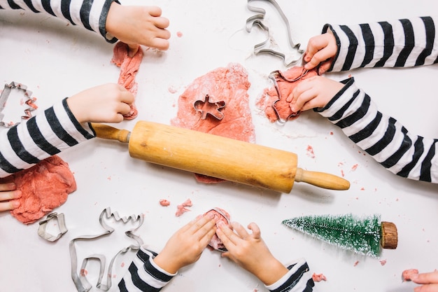 Foto grátis vista de cima das mãos fazendo biscoitos de natal