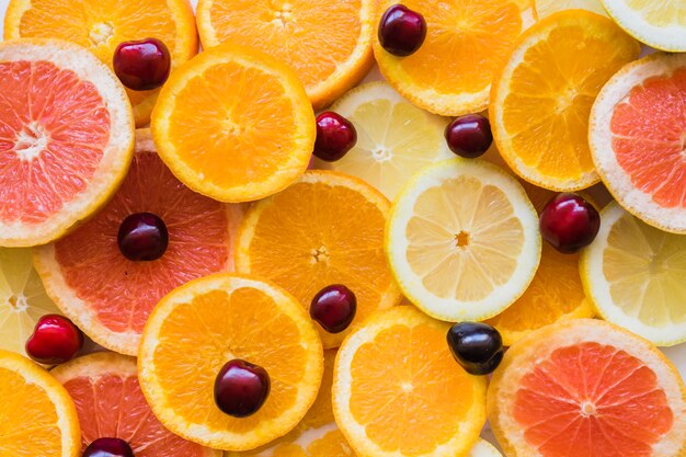 Vista de cima de fatias de frutas com cerejas