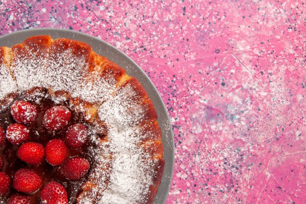 Vista de cima de perto bolo de morango delicioso assado com açúcar em pó na parede rosa claro bolo faça torta de biscoito doce de açúcar