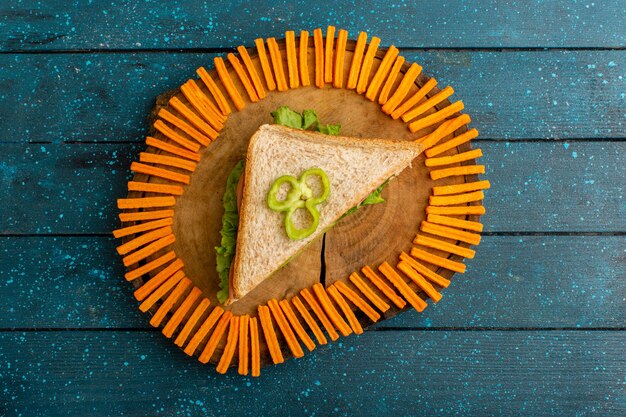 Vista de cima de um sanduíche saboroso com tostas de laranja na mesa azul