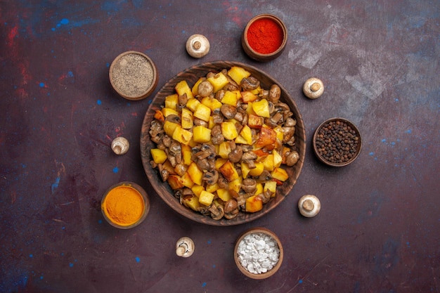 Vista de cima de uma tigela com comida e uma tigela de especiarias com batatas, cogumelos e especiarias coloridas