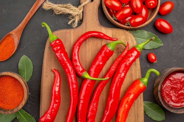 Vista de cima de uma tigela de tomate cereja com pimenta vermelha quente na tábua de cortar