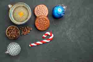 Foto grátis vista de cima de uma xícara de café com sementes de café e detalhes de natal de biscoitos em fundo escuro isolado