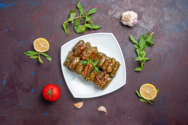 Vista de cima deliciosa folha de dolma carne moída prato dentro da placa no fundo escuro carne prato folha comida jantar