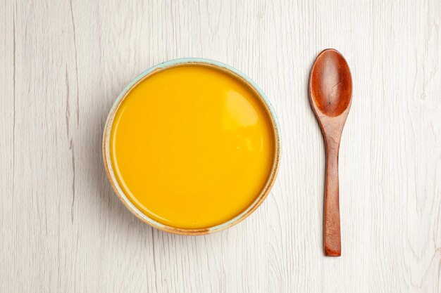 Vista de cima deliciosa sopa de creme sopa de cor amarela em mesa branca sopa molho refeição creme prato
