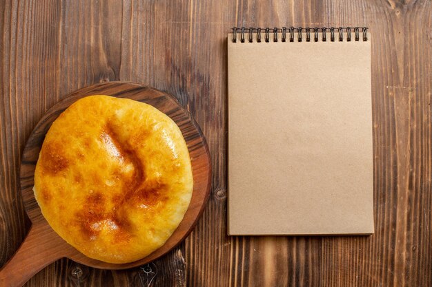 Vista de cima deliciosa torta assada com purê de batatas dentro da mesa de madeira marrom