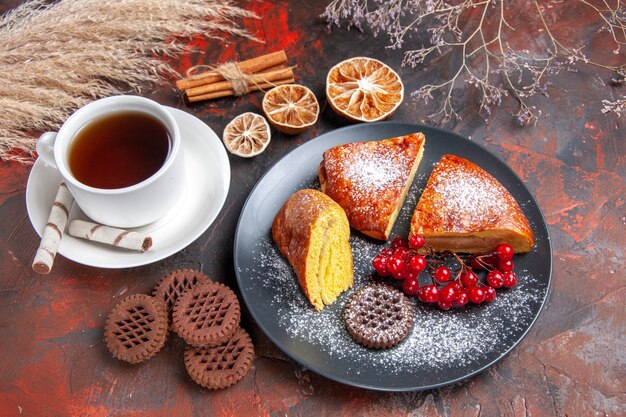 Vista de cima deliciosa torta com uma xícara de chá na mesa escura torta doce chá