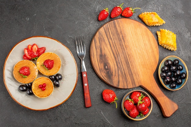 Vista de cima deliciosas panquecas com frutas na superfície escura Bolo Torta Doce de Frutas