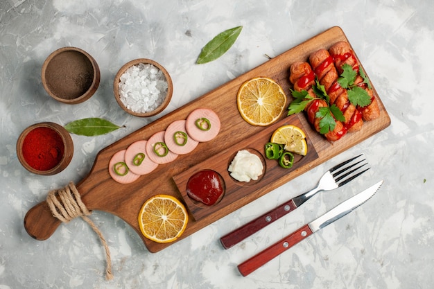 Vista de cima deliciosas salsichas com limão e temperos em comida de mesa branca clara fruta vegetal