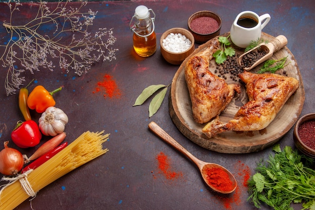 Vista de cima delicioso frango frito com temperos diferentes no espaço escuro