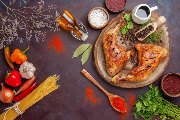 Vista de cima delicioso frango frito com temperos diferentes no espaço escuro