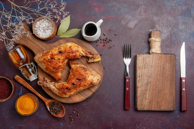 Vista de cima delicioso frango frito com temperos diferentes no espaço escuro