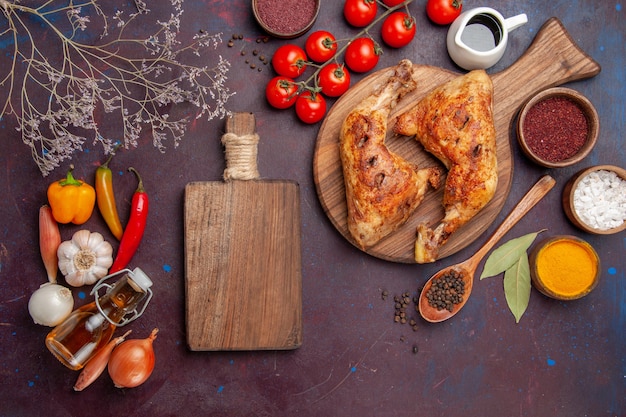 Vista de cima delicioso frango frito com temperos e vegetais no escuro do espaço