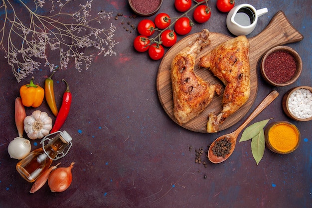 Vista de cima delicioso frango frito com temperos e vegetais no escuro do espaço