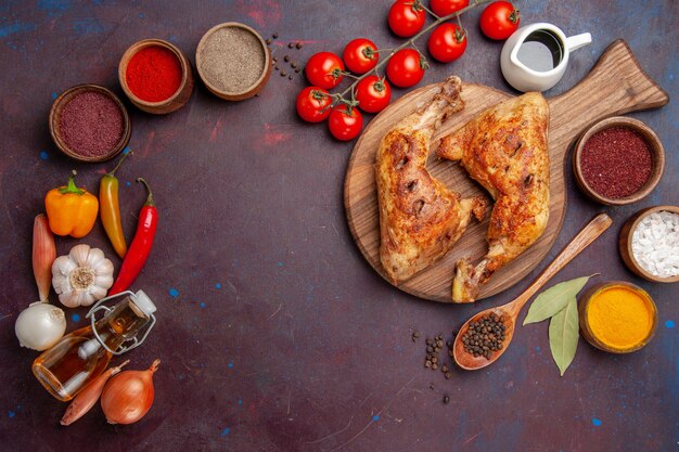 Vista de cima delicioso frango frito com temperos e vegetais no escuro do espaço