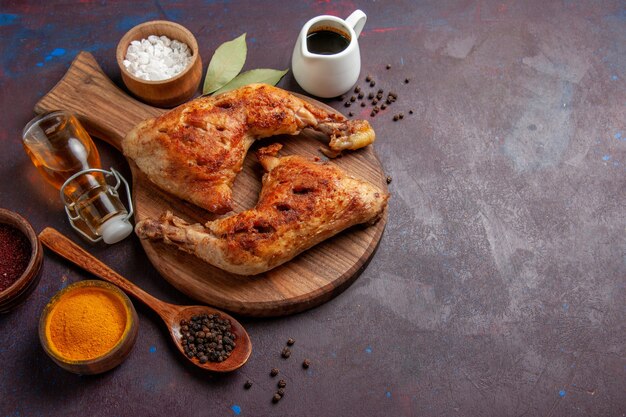 Vista de cima delicioso frango frito com temperos no espaço escuro