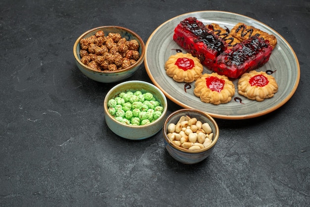 Vista de cima deliciosos bolos de frutas com biscoitos e doces em um fundo escuro torta de biscoito de açúcar torta de chá biscoito doce