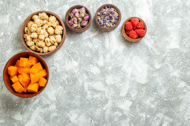 Vista de cima diferentes doces com abóbora fatiada na superfície branca doce chá açúcar bolo muitos