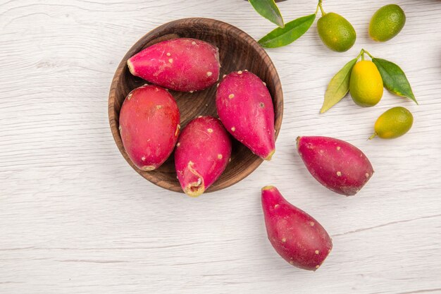 Vista de cima diferentes frutas frescas dentro de pratos em fundo branco frutas dieta tropical madura cor exótica