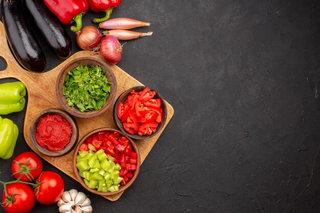 Vista de cima diferentes vegetais frescos e maduros na refeição saudável saudável de salada de fundo cinza