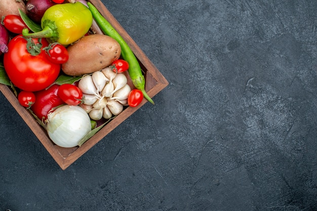 Vista de cima diferentes vegetais frescos na mesa de cor escura salada de vegetais frescos maduros