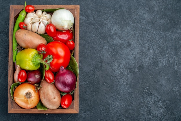 Vista de cima diferentes vegetais frescos na mesa de cor escura salada de vegetais frescos maduros