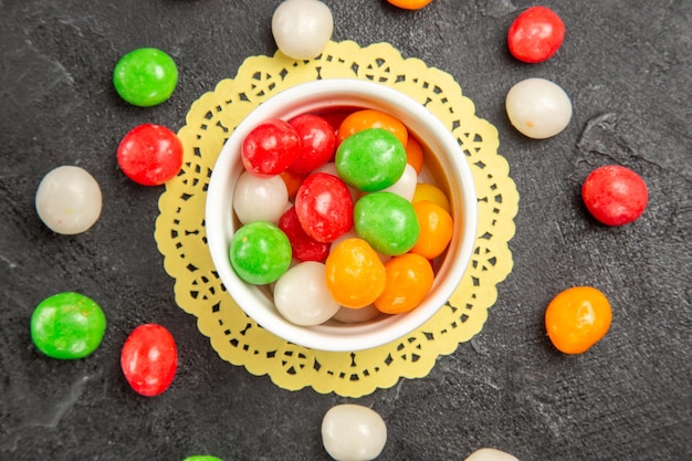 Vista de cima, doces coloridos na superfície escura, cor arco-íris, chá doce