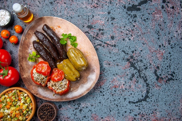 Vista de cima dolma de berinjela com tomate cozido e pimentão recheado com carne moída dentro do prato, cor do prato jantar comida refeição