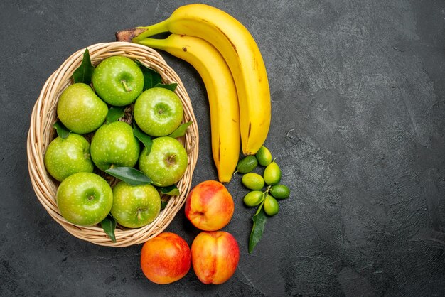 Vista de cima em close-up frutas maçãs na cesta nectarinas frutas cítricas e bananas