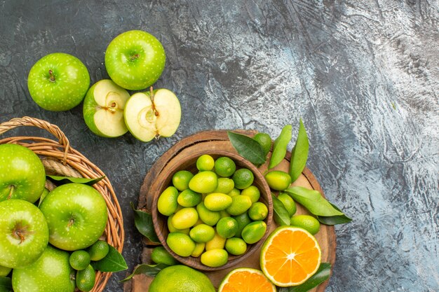 Vista de cima em close-up maçãs no tabuleiro com diferentes frutas cítricas cesta de frutas cítricas maçãs