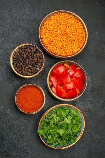 Foto grátis vista de cima em close-up tigelas de lentilha com tomates e especiarias ervas pimenta-do-reino