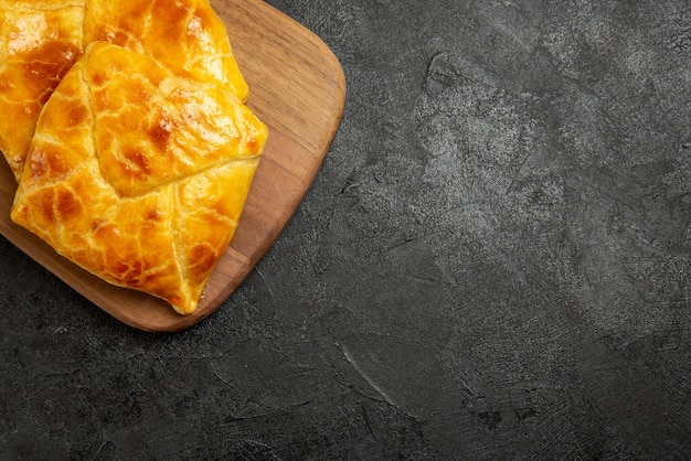 Vista de cima em close-up tortas apetitosas na tábua e tortas apetitosas no lado esquerdo da mesa