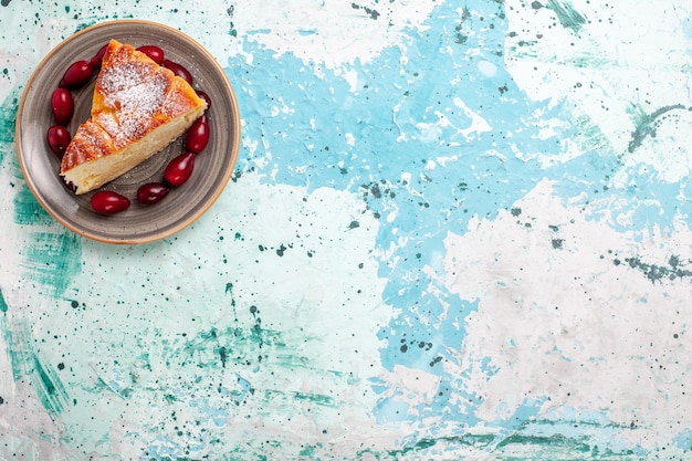 Vista de cima fatia de bolo com dogwoods vermelhos frescos em fundo azul claro Bolo de frutas assar torta biscoito doce