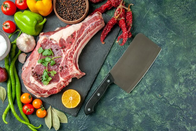 Vista de cima fatia de carne crua com vegetais frescos e pimenta no fundo azul escuro alimentos carne cozinha animal frango vaca açougueiro