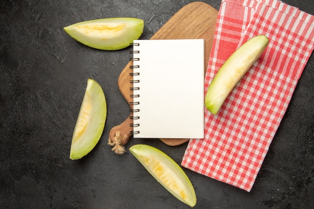 Vista de cima fatias de melão fresco frutas deliciosas no chão escuro frutas doces de verão