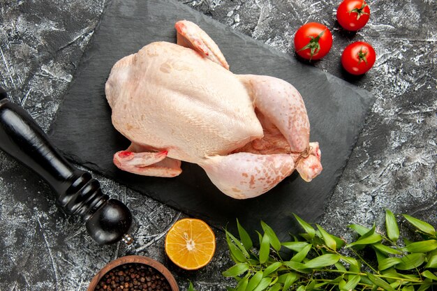 Vista de cima frango cru fresco com tomates em fundo claro-escuro refeição de cozinha foto animal frango cor fazenda comida