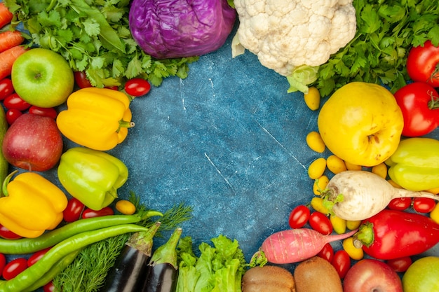 Foto grátis vista de cima frutas e vegetais tomates cereja cumcuat marmelo maçãs beringelas rabanete coentro couve-flor couve-flor na mesa azul