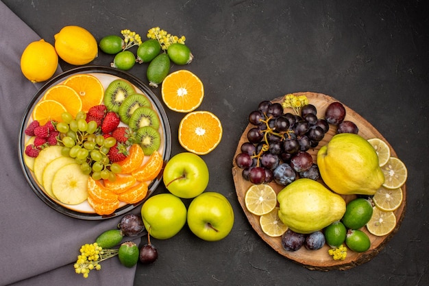 Vista de cima frutas frescas e frutas maduras na superfície escura