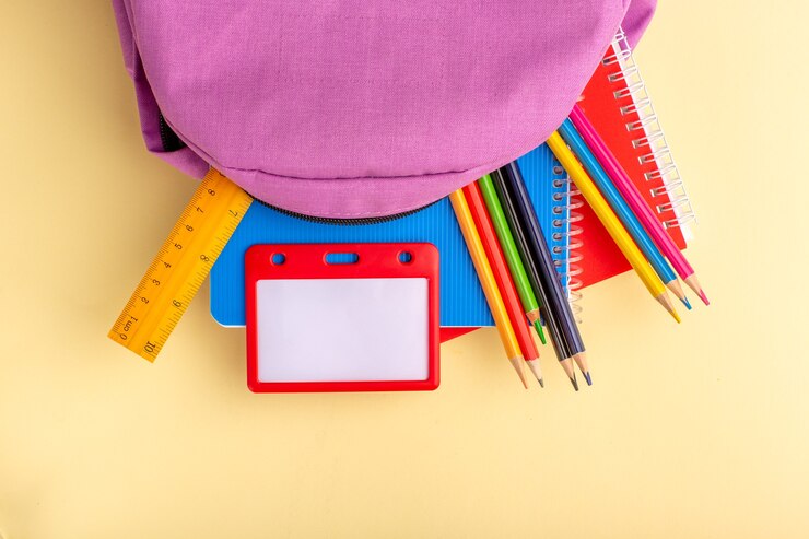 Foto grátis vista de cima lápis coloridos com cadernos e bolsa roxa na mesa amarelo claro bloco de notas de caneta escolar.