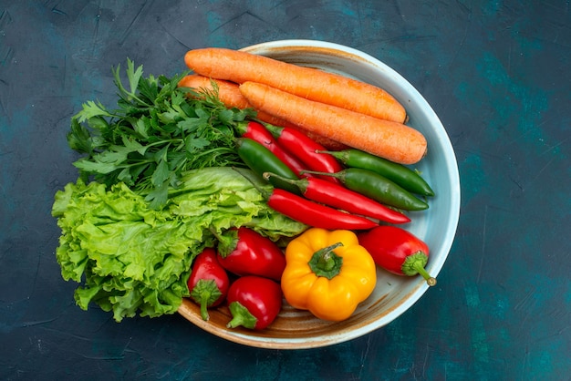 Vista de cima legumes frescos dentro do prato na mesa azul lanche almoço salada comida vegetal