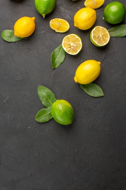 Vista de cima limões frescos frutas ácidas na mesa escura frutas cítricas lima